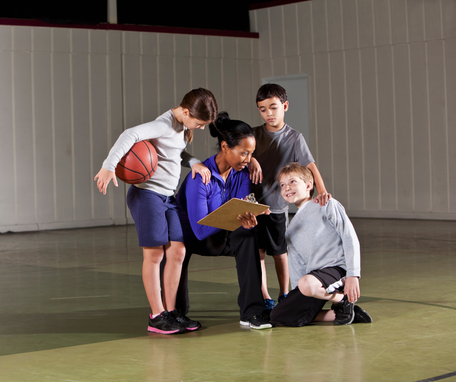 coach di basket che comunica con i suoi piccoli atleti