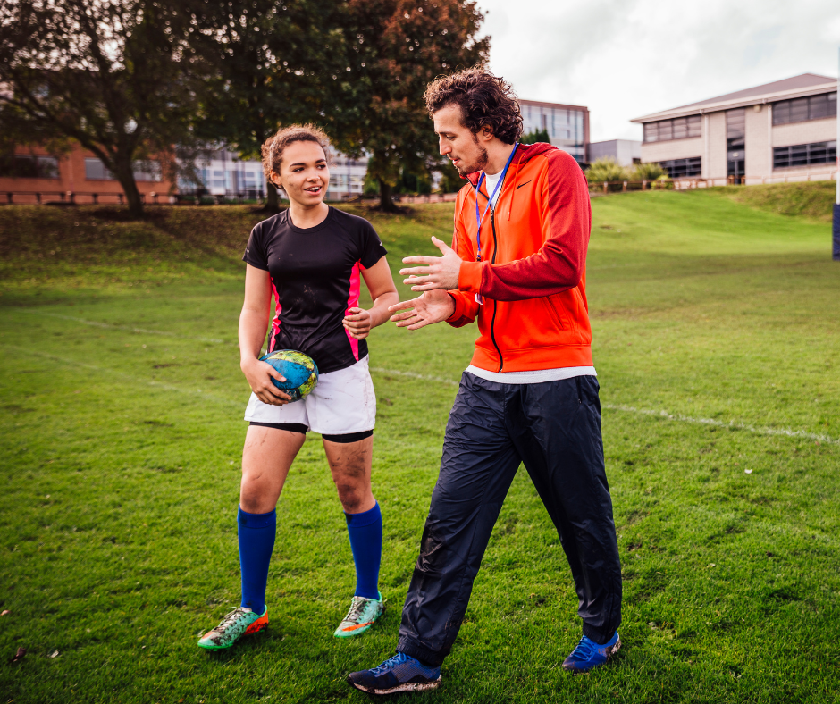 allenatore di rugby che comunica in modo efficace con una sua allieva
